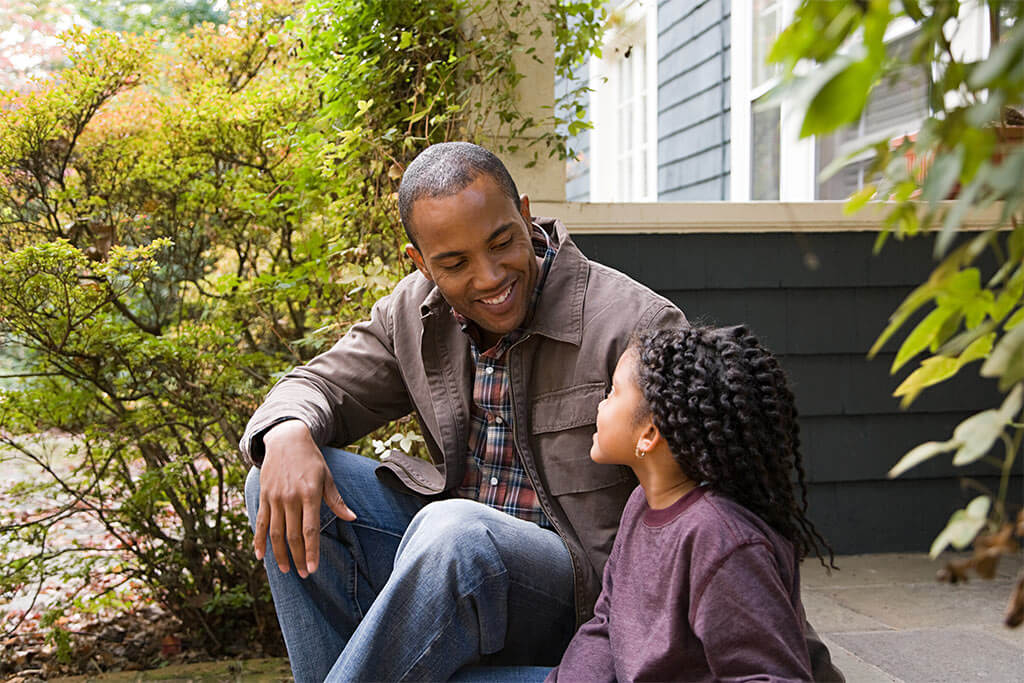 Father and daughter outside house